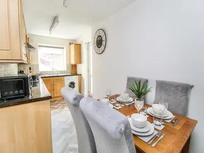 a kitchen with a wooden table with chairs around it at 2 Bed House, Sleeps 5, Ideal for Contractors, St Helens, Long Term Stays Weekly & Monthly Offers in Saint Helens