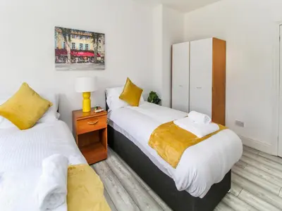 a bedroom with two beds and a night stand with a lamp at 2 Bed House, Sleeps 5, Ideal for Contractors, St Helens, Long Term Stays Weekly & Monthly Offers in Saint Helens