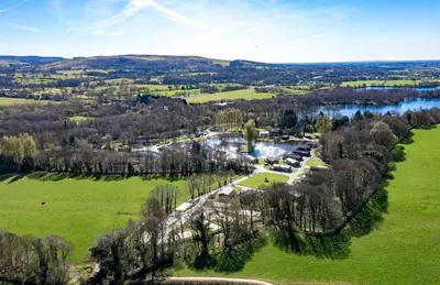 an aerial view of a field and a river at Bowland Lakes Leisure Village in Forton