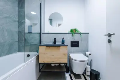 a bathroom with a sink and a toilet and a tub at Modern Central Preston Apt King Bed & Smart TV in Preston