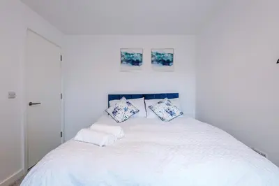 a white bed with two pillows on top of it at Modern Central Preston Apt King Bed & Smart TV in Preston