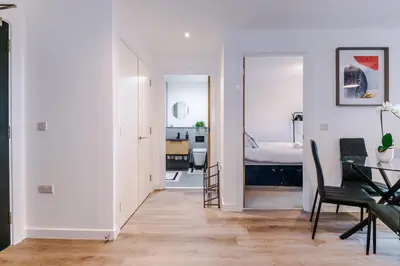 a living room with a table and a bedroom at Modern Central Preston Apt King Bed & Smart TV in Preston