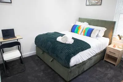 a bedroom with a bed with a chair and a desk at Luxury Preston Home 3 Beds Sleeps 6 in Preston