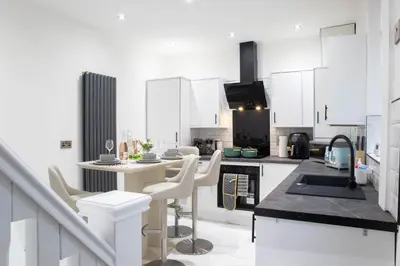 a white kitchen with white cabinets and a counter top at Luxury Preston Home 3 Beds Sleeps 6 in Preston