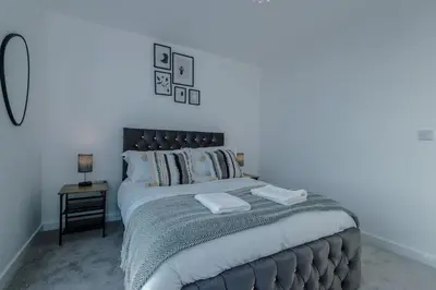 a bedroom with a large bed with a black headboard at Luxurious 2Bed Apartment, Sleeps 6, 3 beds in Preston