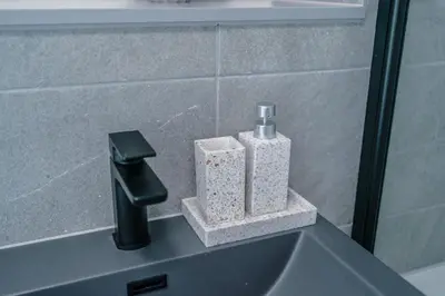 a bathroom sink with a faucet and two soap dispensers at Luxurious 2Bed Apartment, Sleeps 6, 3 beds in Preston