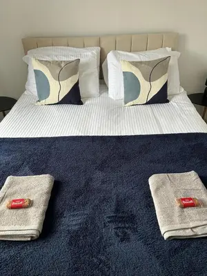a bed with two towels and pillows on it at Merseyside cosy 2 bed townhouse sleeps 5 in Liverpool