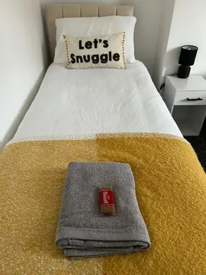 a bed with a pillow and a towel on it at Merseyside cosy 2 bed townhouse sleeps 5 in Liverpool