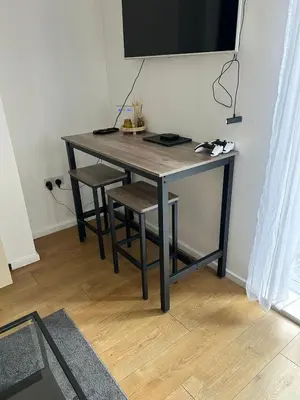 a table with two chairs and a television on a wall at Merseyside cosy 2 bed townhouse sleeps 5 in Liverpool