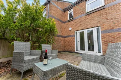 a bottle of wine sitting on a table with chairs at Merseyside cosy 2 bed townhouse sleeps 5 in Liverpool