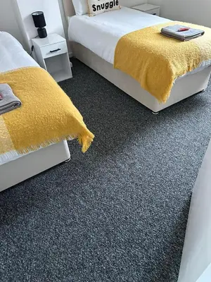 a bedroom with two beds and a yellow carpet at Merseyside cosy 2 bed townhouse sleeps 5 in Liverpool