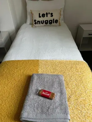 a bottle of lipstick sitting on top of a bed at Merseyside cosy 2 bed townhouse sleeps 5 in Liverpool