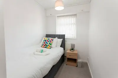 a small bedroom with a bed and a small table at Close to City Centre - Mins Away from Anfield Stadium - Free Street Parking in Liverpool