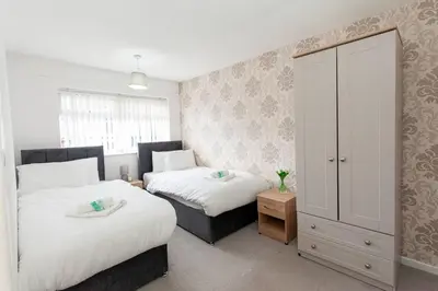 a bedroom with two beds and a cabinet at Close to City Centre - Mins Away from Anfield Stadium - Free Street Parking in Liverpool