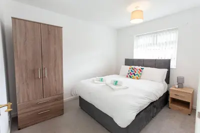 a bedroom with a large bed and a wooden cabinet at Close to City Centre - Mins Away from Anfield Stadium - Free Street Parking in Liverpool