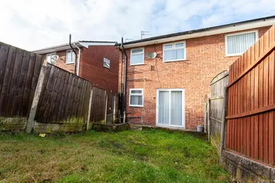a brick house with a fence and a yard at Close to City Centre - Mins Away from Anfield Stadium - Free Street Parking in Liverpool