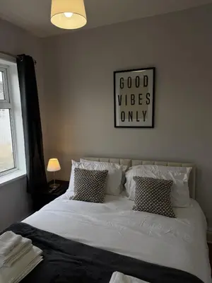 a bedroom with a large white bed with two pillows at Month Stays Central 3 bed Three Bedroom House by Brookland Stays Serviced Accommodation & Short Lets in Preston with Free WiFi in Farington