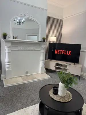 a living room with a fireplace and a mirror at Month Stays Central 3 bed Three Bedroom House by Brookland Stays Serviced Accommodation & Short Lets in Preston with Free WiFi in Farington