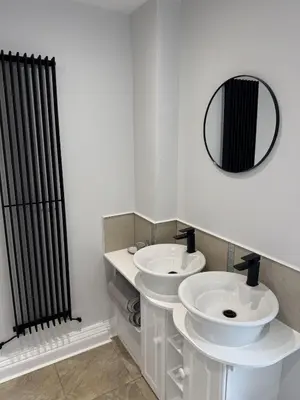 a bathroom with two sinks and a black radiator at Month Stays Central 3 bed Three Bedroom House by Brookland Stays Serviced Accommodation & Short Lets in Preston with Free WiFi in Farington