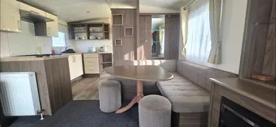 a small living room with a table and a kitchen at BILOT Caravan in Heysham