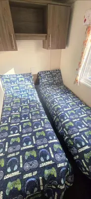 two beds in a small room with a bedspread on it at BILOT Caravan in Heysham