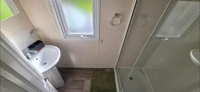 a bathroom with a shower and a toilet and a sink at BILOT Caravan in Heysham