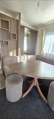 a wooden table and chairs in a living room at BILOT Caravan in Heysham