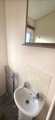 a bathroom with a white sink and a mirror at BILOT Caravan in Heysham