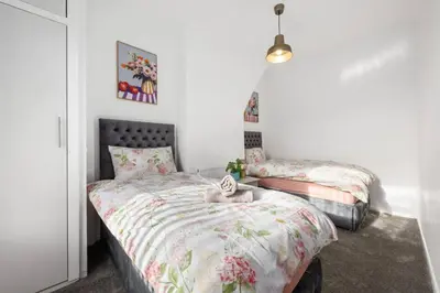 a bedroom with two beds and a bed with a comforter at Modern & Stylish Stay in the Heart of St Hubert in Great Harwood