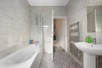 a bathroom with a tub and a sink and a shower at Modern & Stylish Stay in the Heart of St Hubert in Great Harwood