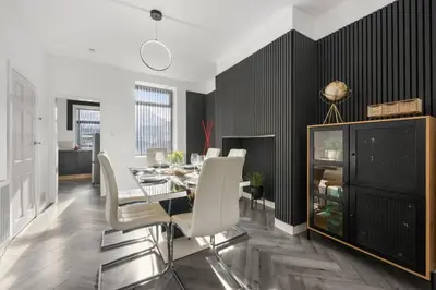a dining room with a table and white chairs at Modern & Stylish Stay in the Heart of St Hubert in Great Harwood