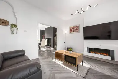 a living room with a couch and a fireplace at Modern & Stylish Stay in the Heart of St Hubert in Great Harwood
