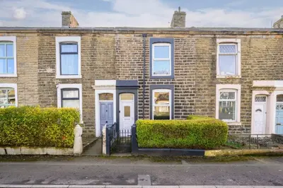 an old brick house with white doors and bushes at Modern & Stylish Stay in the Heart of St Hubert in Great Harwood