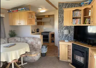a small living room with a table and a television at Seaside Arizona in Morecambe