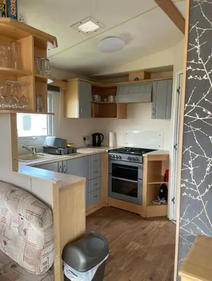 a small kitchen with a stove and a sink at Seaside Arizona in Morecambe