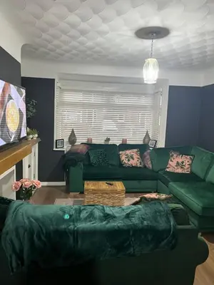 a living room with a green couch and a table at Our Happy Place West Derby in Deysbrook