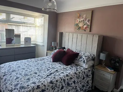 a bedroom with a bed with a blue and white comforter at Our Happy Place West Derby in Deysbrook