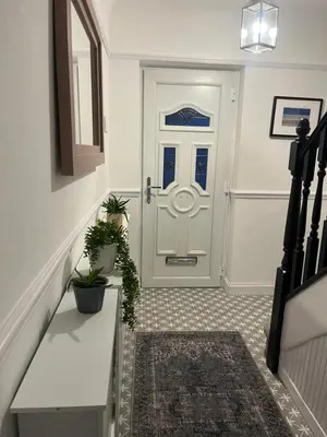 a hallway with a white door with a rug at Our Happy Place West Derby in Deysbrook