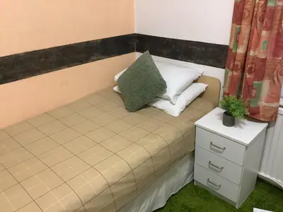 a small bed with two pillows and a night stand at King Edward Guesthouse in Blackpool
