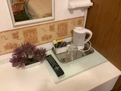 a counter top with a coffee maker and flowers on it at King Edward Guesthouse in Blackpool