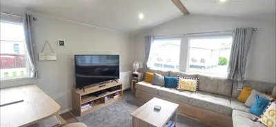 a living room with a couch and a flat screen tv at T&K's Caravan in Morecambe
