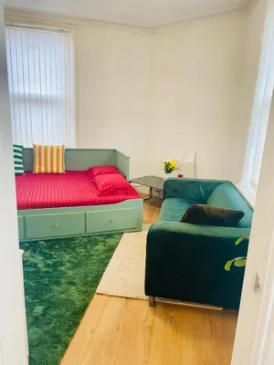 a living room with a couch and a bed at Cozy Cottage in Liverpool