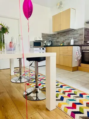 a kitchen with a table and a pink balloon at Cozy Cottage in Liverpool