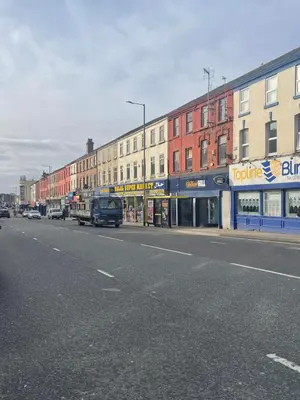 a city street with buildings and a street at Cozy Cottage in Liverpool
