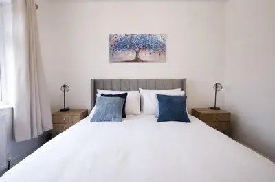 a bedroom with a white bed with blue pillows at Westhoughton 3 Bedroom House - Free Parking in Westhoughton