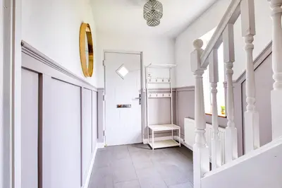 a hallway with a staircase with a mirror on the wall at Westhoughton 3 Bedroom House - Free Parking in Westhoughton