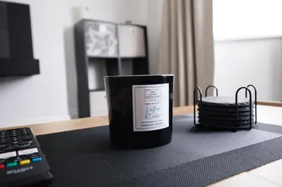 a candle sitting on a table next to a laptop at Westhoughton 3 Bedroom House - Free Parking in Westhoughton