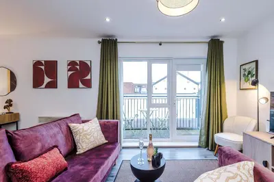 a living room with a purple couch and a balcony at Centrally Located Formby Flat by 53 Degrees Property, Perfect for Work & Leisure in Formby