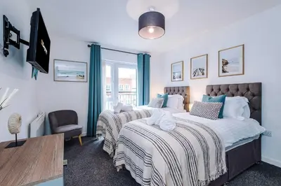 a bedroom with two beds and a window at Centrally Located Formby Flat by 53 Degrees Property, Perfect for Work & Leisure in Formby