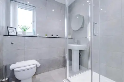 a bathroom with a shower and a toilet and a sink at Centrally Located Formby Flat by 53 Degrees Property, Perfect for Work & Leisure in Formby